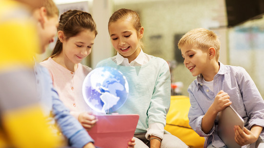 Children are watching a hologram in a classroom setting.