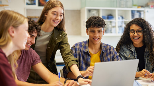 Students work together on a laptop