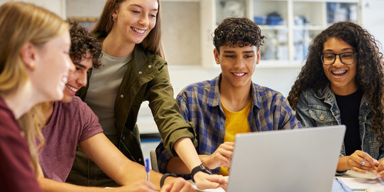 Students work together on a laptop