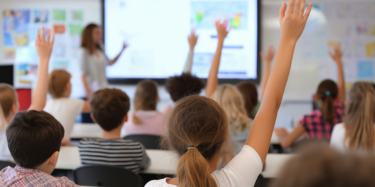 Classroom Several students raise their hands in class.